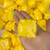 A hand holds a pile of bright yellow, squishy fidget cubes for stress relief.