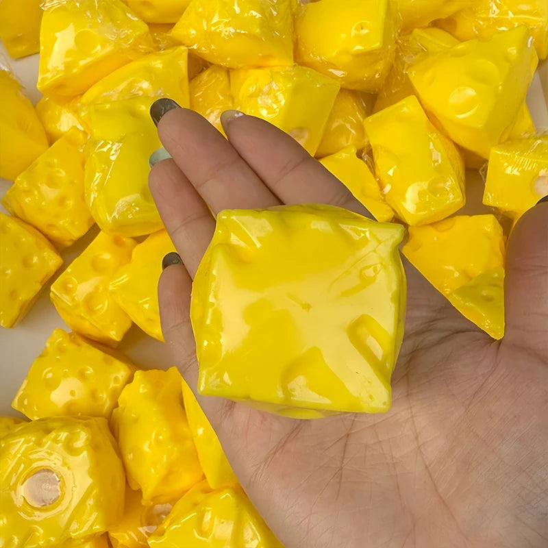 A hand holds a pile of bright yellow, squishy fidget cubes for stress relief.