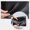 Eine Hand hält eine schwarze Leder-Manschette für Herren.