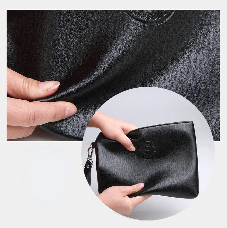 Eine Hand hält eine schwarze Leder-Manschette für Herren.