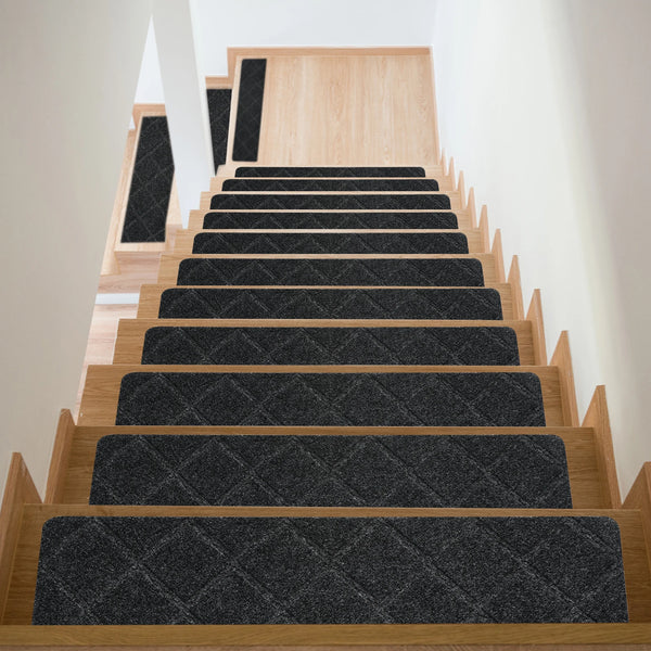 A modern wooden staircase with dark gray non-slip carpet treads leading upwards.