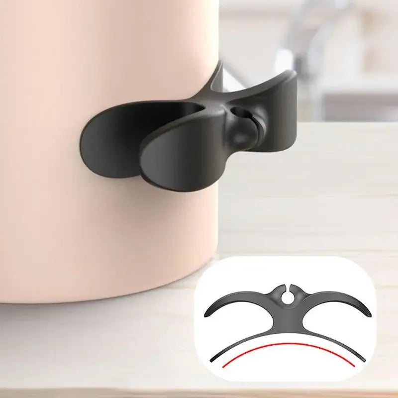 A black cord organizer and wire winder is shown resting on a light-colored surface.