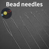 A collection of flexible stainless steel bead needles and a yellow bead on a red string for jewelry making.