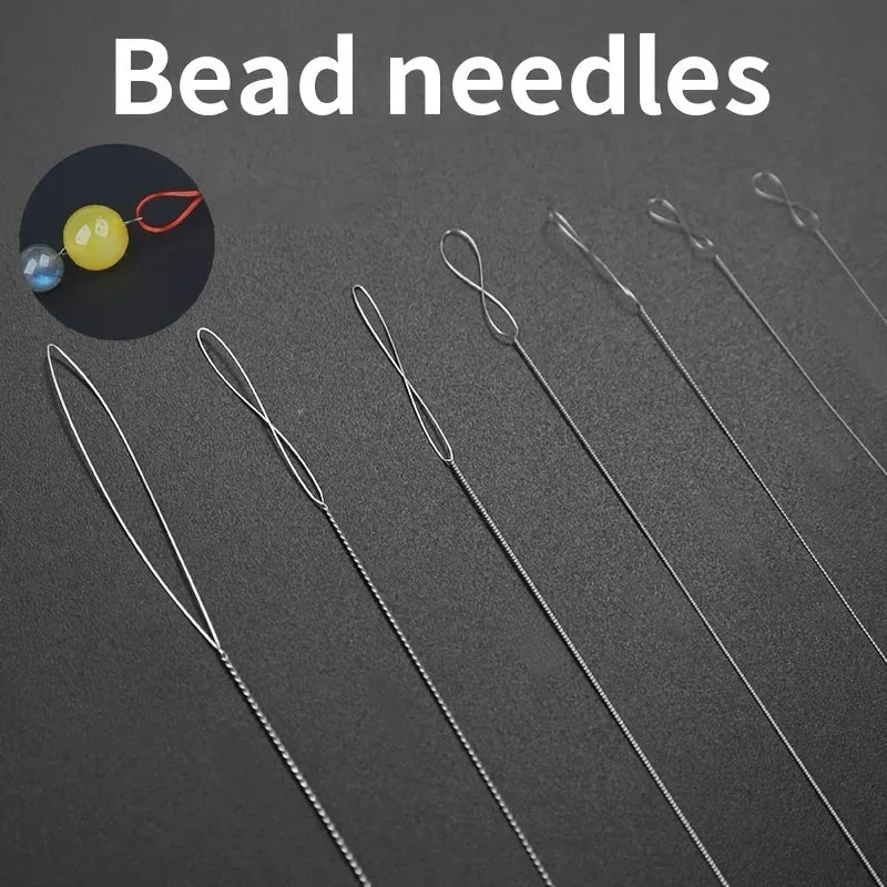 A collection of flexible stainless steel bead needles and a yellow bead on a red string for jewelry making.