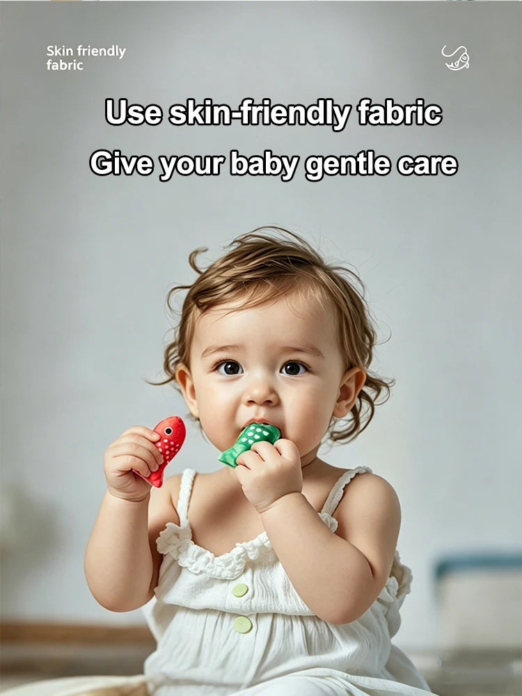 A baby is playing with a red and green Montessori fabric fishing game.