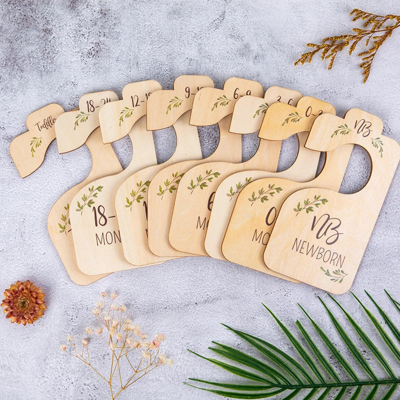 A set of eight wooden baby closet dividers showing various sizes for newborn to two-year-old babies.