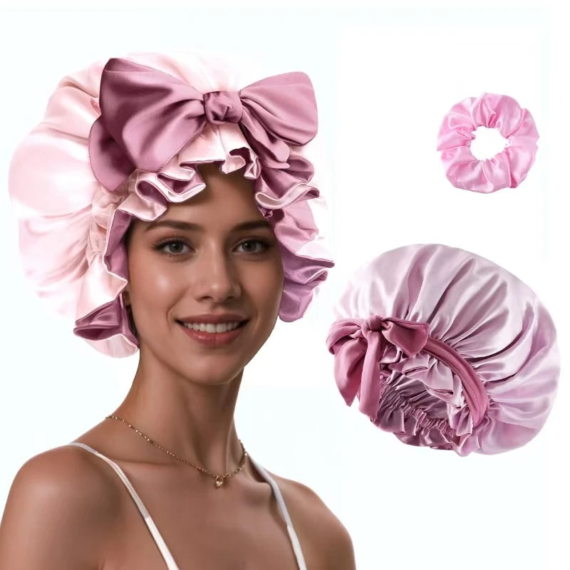 A woman models a pink silk satin sleep bonnet with adjustable straps, showing the bonnet and separate fabric pieces.