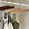 A wooden hanging clothes rack with multiple metal hooks displaying various garments.