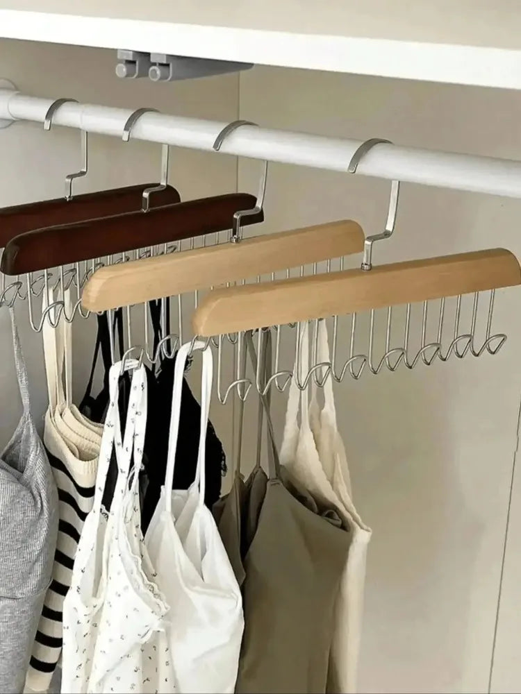 A wooden hanging clothes rack with multiple metal hooks displaying various garments.