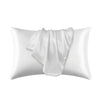 Una funda de almohada de satén de seda blanca de lujo, doblada y drapeada.