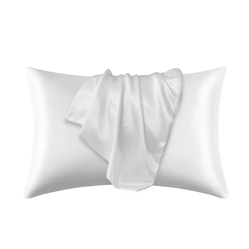 Una funda de almohada de satén de seda blanca de lujo, doblada y drapeada.