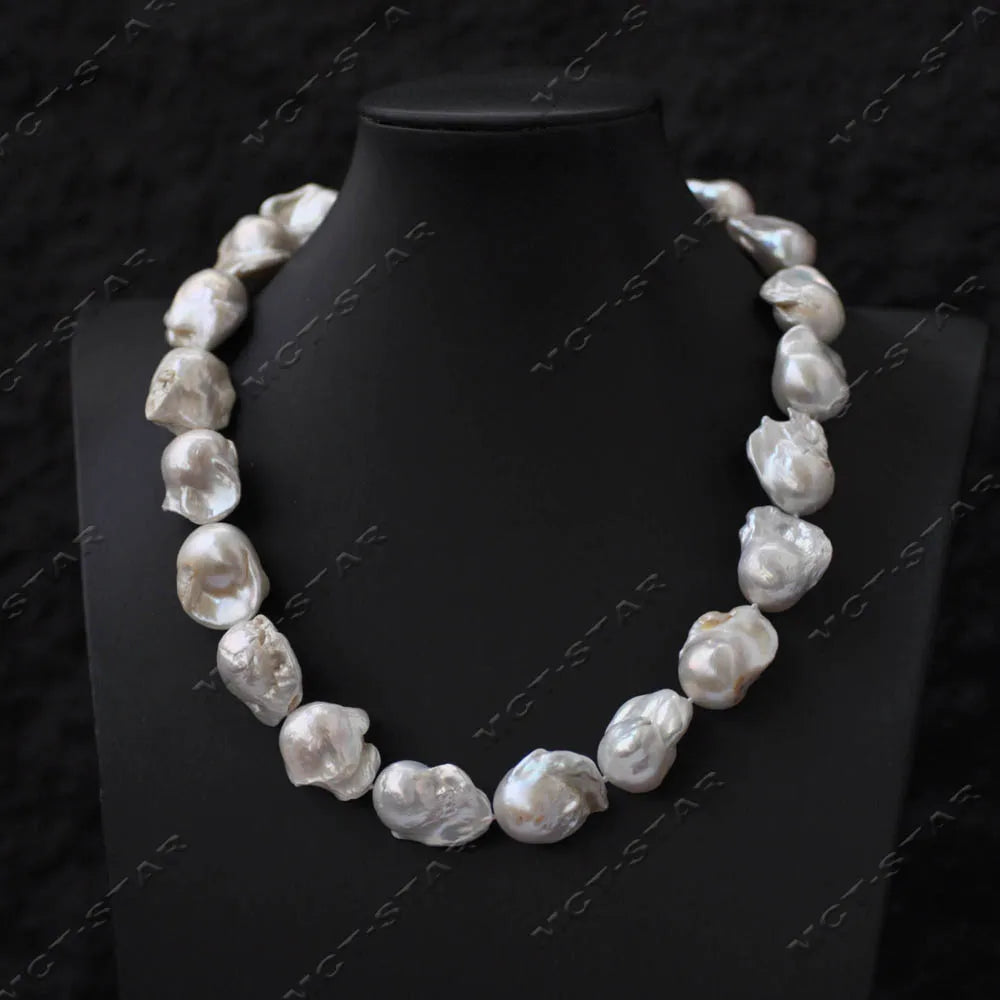 A close-up of a white baroque keshi pearl necklace displayed on a black mannequin.