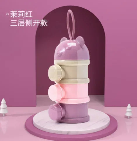A stack of three pink and cream bear-shaped baby food storage containers with hinged lids.