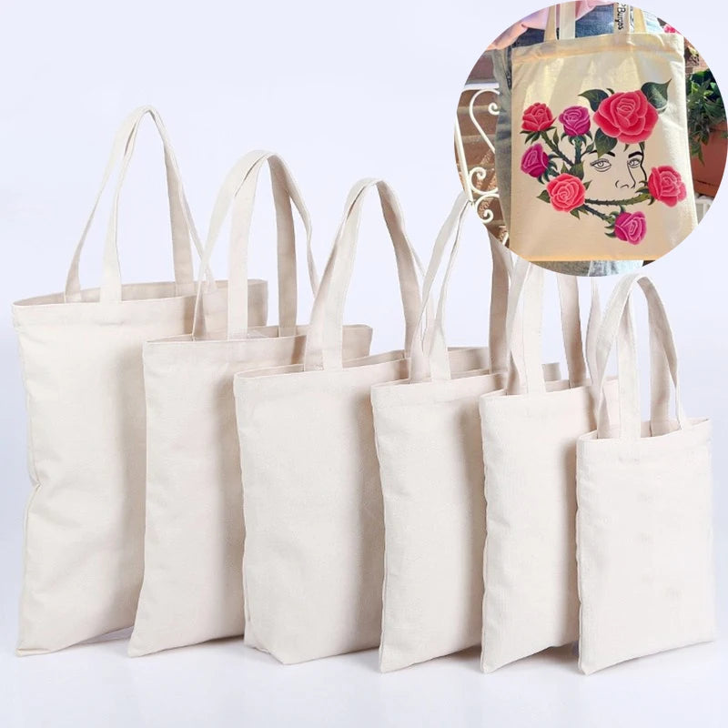 A set of natural canvas shopping tote bags with handles and a decorative fabric element.