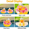Detail display of a yellow rubber duck decoration featuring a crown, sunglasses, and pearl necklace in various styles.