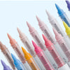 A collection of nine acrylic paint marker pens in various colors and shades with fine tips.