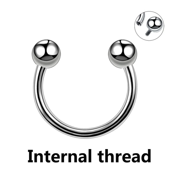 A close-up view of a polished titanium horseshoe septum ring with an internal thread and a separate screw.