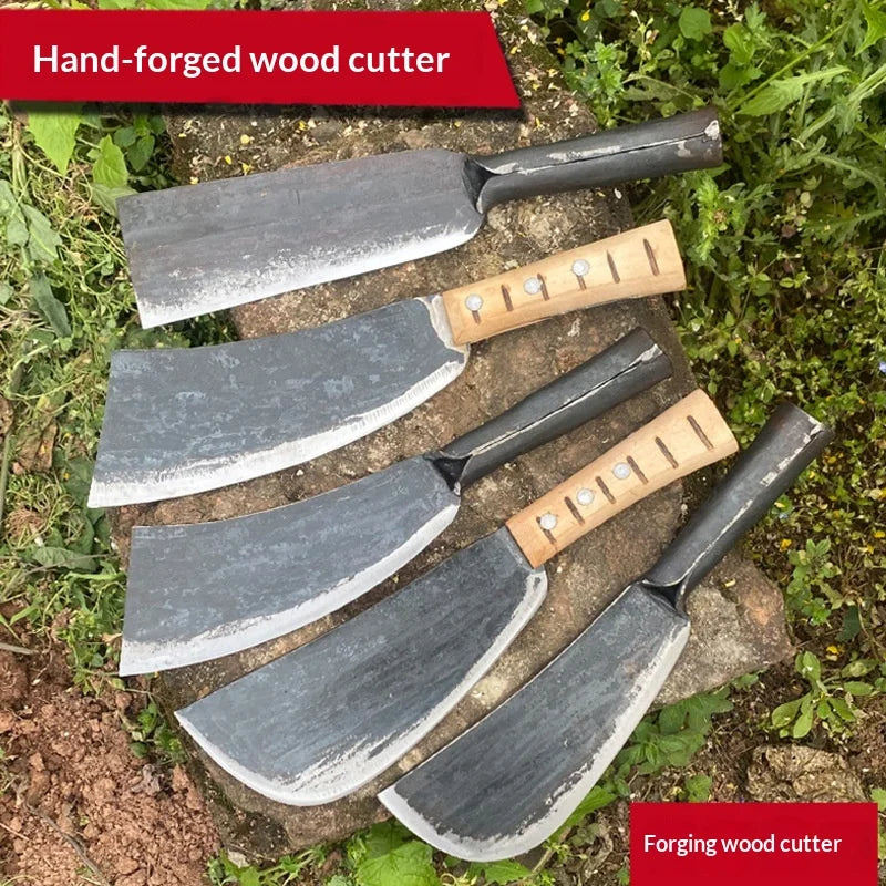 A set of hand-forged steel wood cutters with wooden handles resting on a stone and greenery.