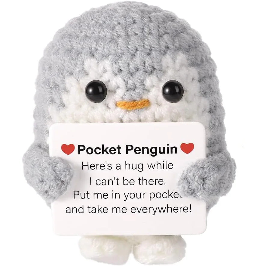 Handmade knitted grey penguin doll with a white card featuring a hug message