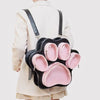 A pink and black multi-pocket backpack with cat paw print design worn on a person's back.