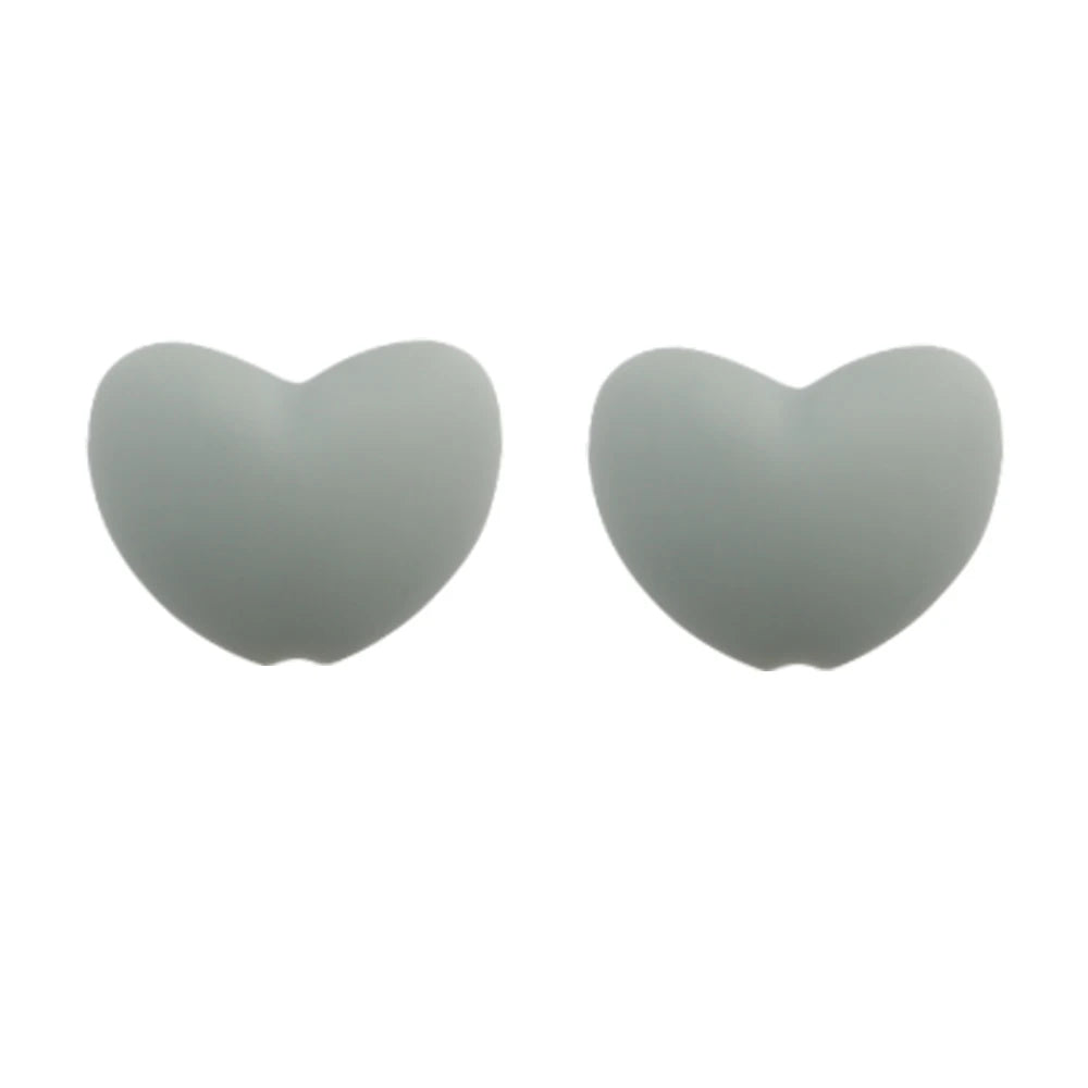 A pair of smooth, heart-shaped silicone beads in a light gray color.