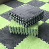 A stack of gray soft plush interlocking floor tiles on a green and gray checkered rug.