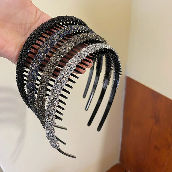 Eine Hand hält ein schwarzes, mit Diamanten besetztes elastisches Stirnband mit mehreren Strängen.