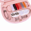 A pink portable mini sewing kit with colored threads, pins, and needles inside the storage box.