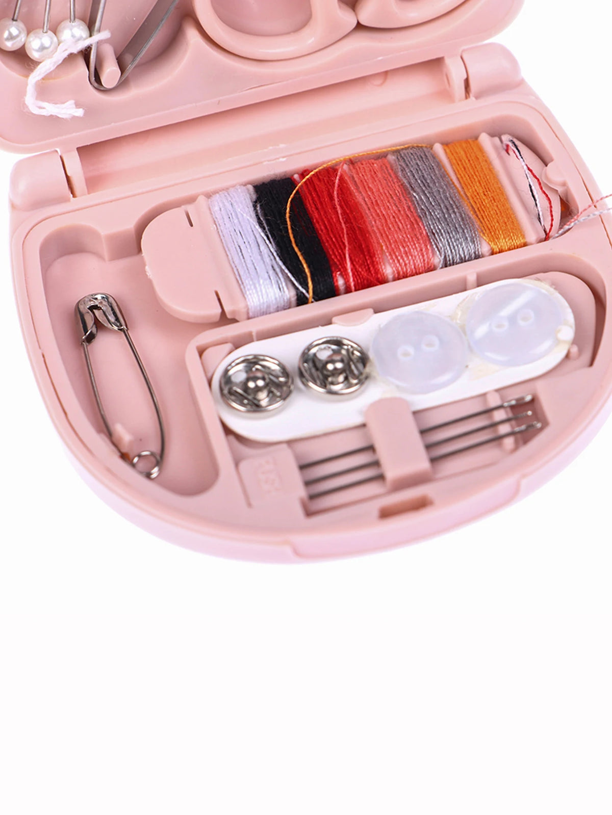 A pink portable mini sewing kit with colored threads, pins, and needles inside the storage box.