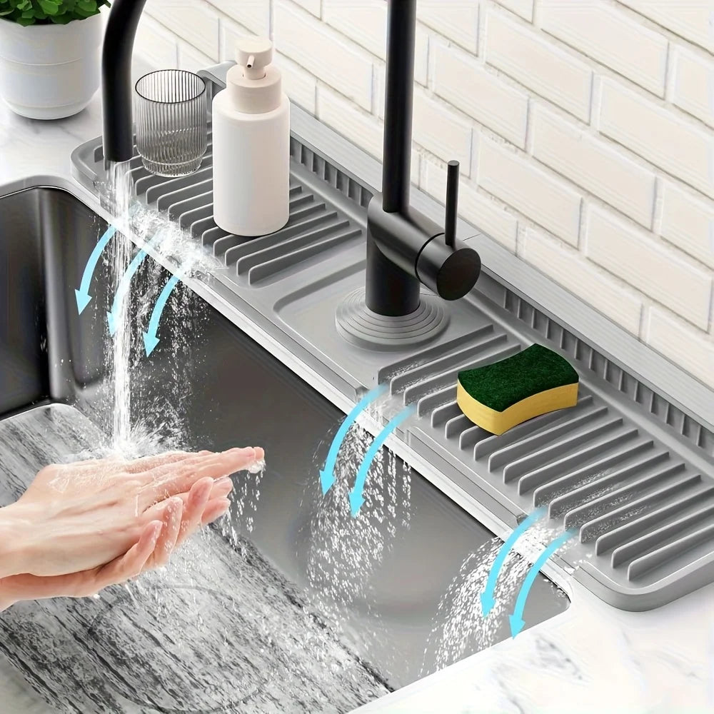 A hand is washing soap and water under a kitchen sink splash guard device.
