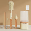 A set of silicone baby bottle brushes, including a bottle brush and a separate brush head, displayed on a light surface.