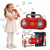 A young girl is holding a red microphone next to an orange karaoke machine and its box.