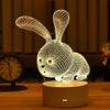 A white wireframe rabbit 3D illusion LED night light lamp resting on a wooden surface.