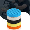A stack of five colored polishing sponge pads, including blue, white, black, yellow, and orange.