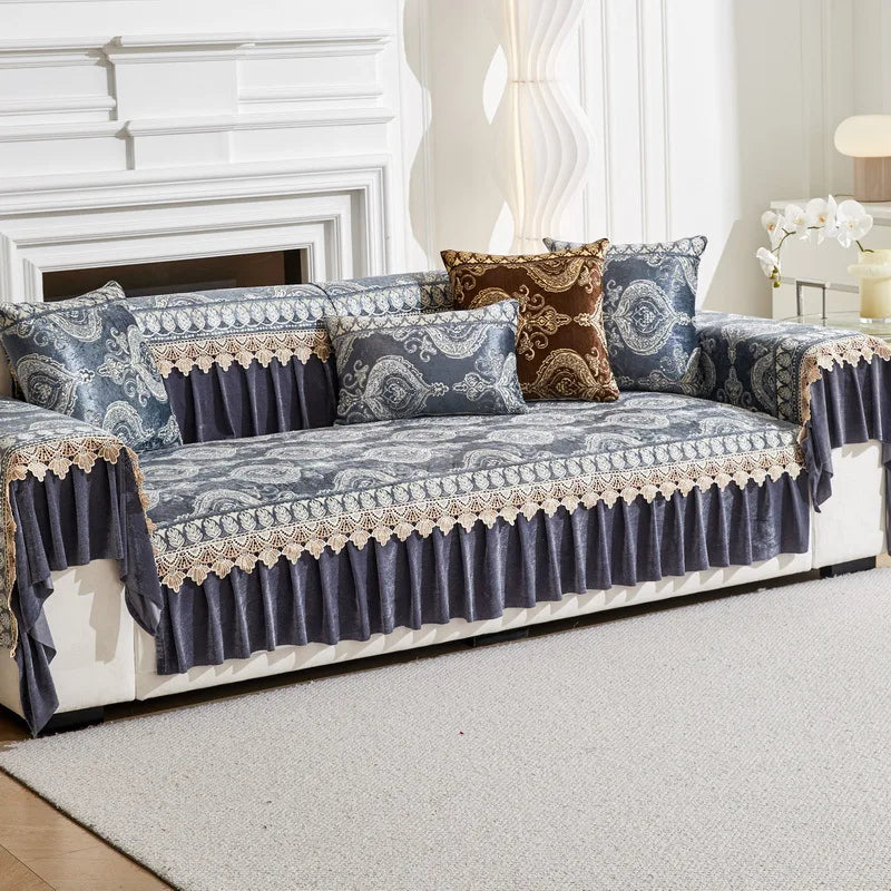 A navy blue sofa covered with an ornate patterned fabric and decorative trim, featuring accent pillows.