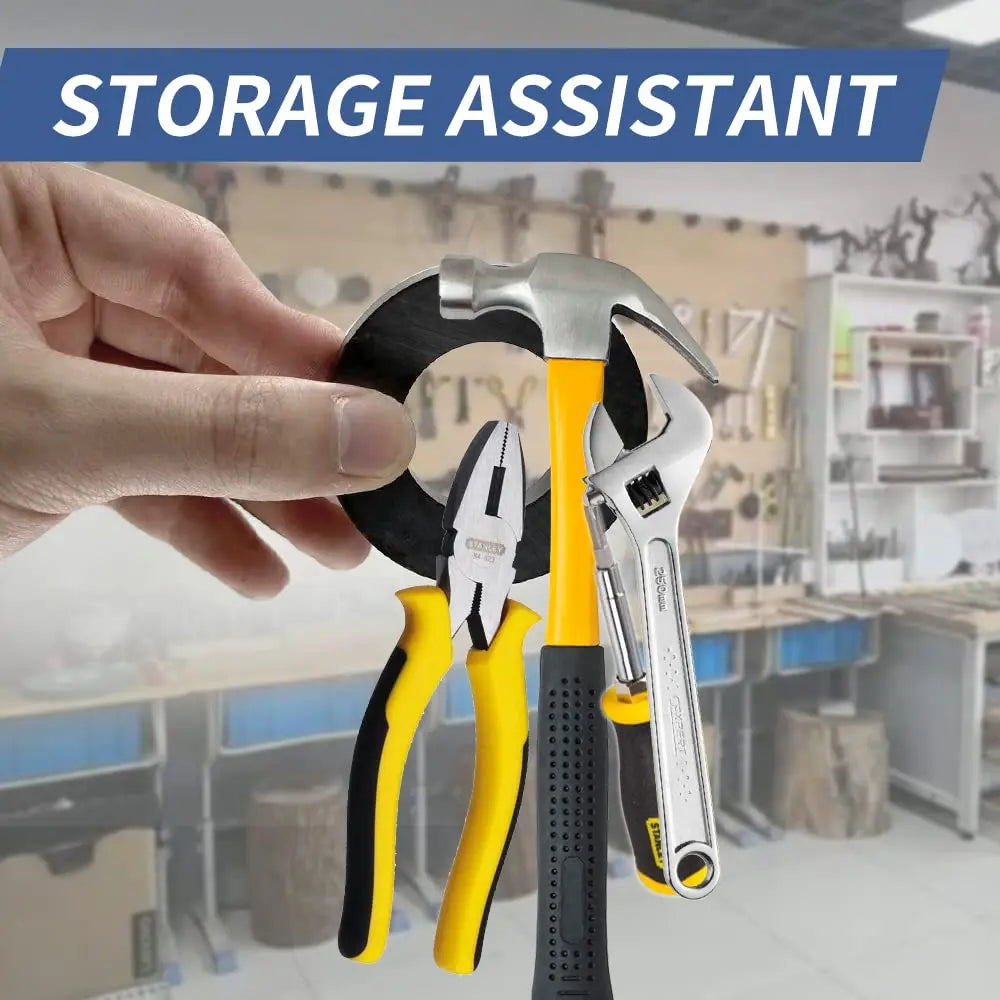 A hand holds a yellow and black tool set, including a hammer and pliers, in a workshop setting.