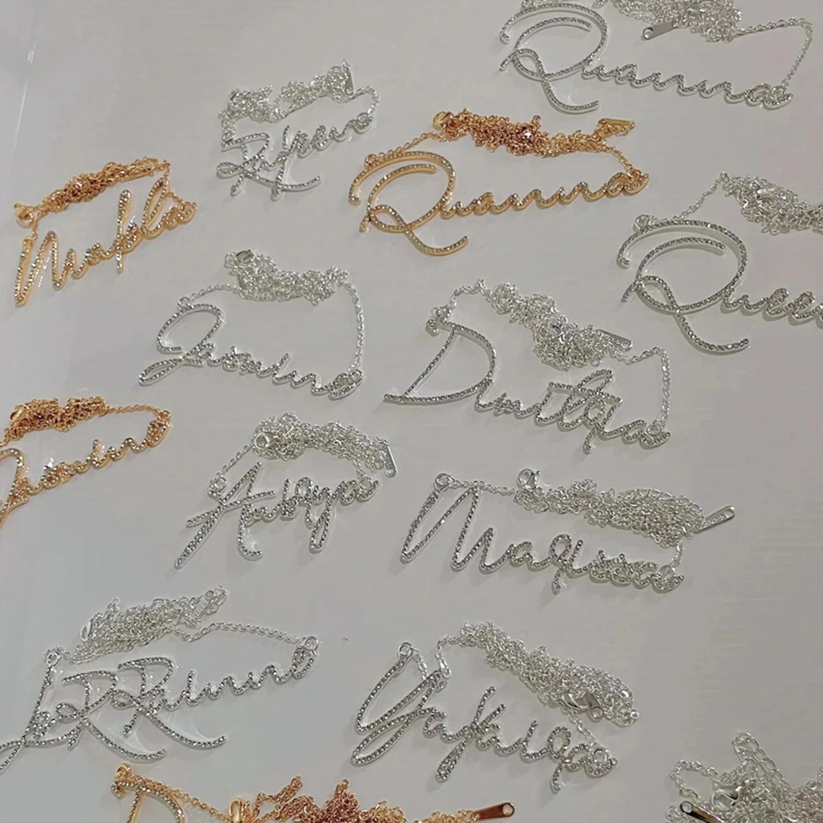 Collection de colliers personnalisés avec noms en tons or et argent.