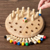 A hand is placing wooden chess pieces into holes on a circular wooden board for a memory game.