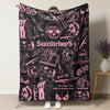 A black blanket featuring pink and white retro skull and clown horror art designs.