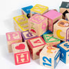 A collection of colorful wooden word building blocks in various colors and shapes for early learning.