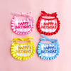 A set of four fabric birthday hats and bibs for pets in pink, red, yellow, and blue plaid patterns.