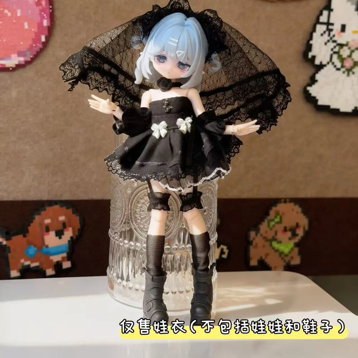 A female BJD doll wearing a black maid dress outfit with a lace veil and boots.