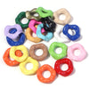 A collection of colorful acrylic spacer beads in various shades including green, purple, pink, yellow, and black.