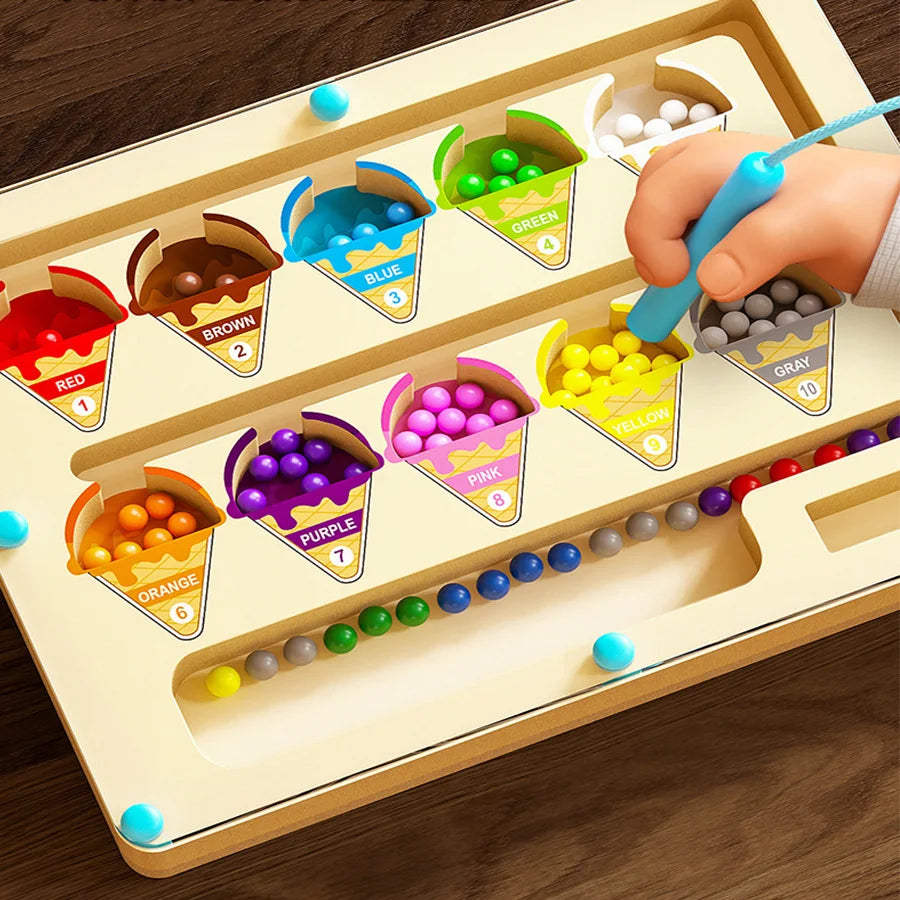 A wooden magnetic color sorting maze board with various colored plastic cups and balls for toddlers.