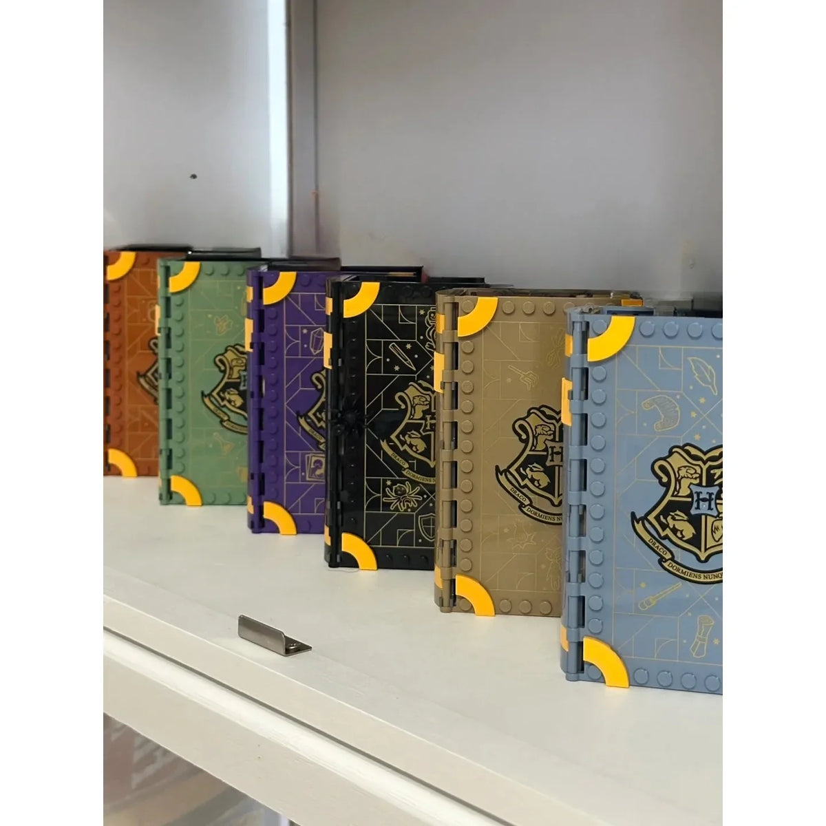 A collection of six fantasy theme model book building blocks in various colors and designs displayed on a white surface.