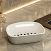 A white double-layer draining soap dish with a non-slip base resting on a marble surface.