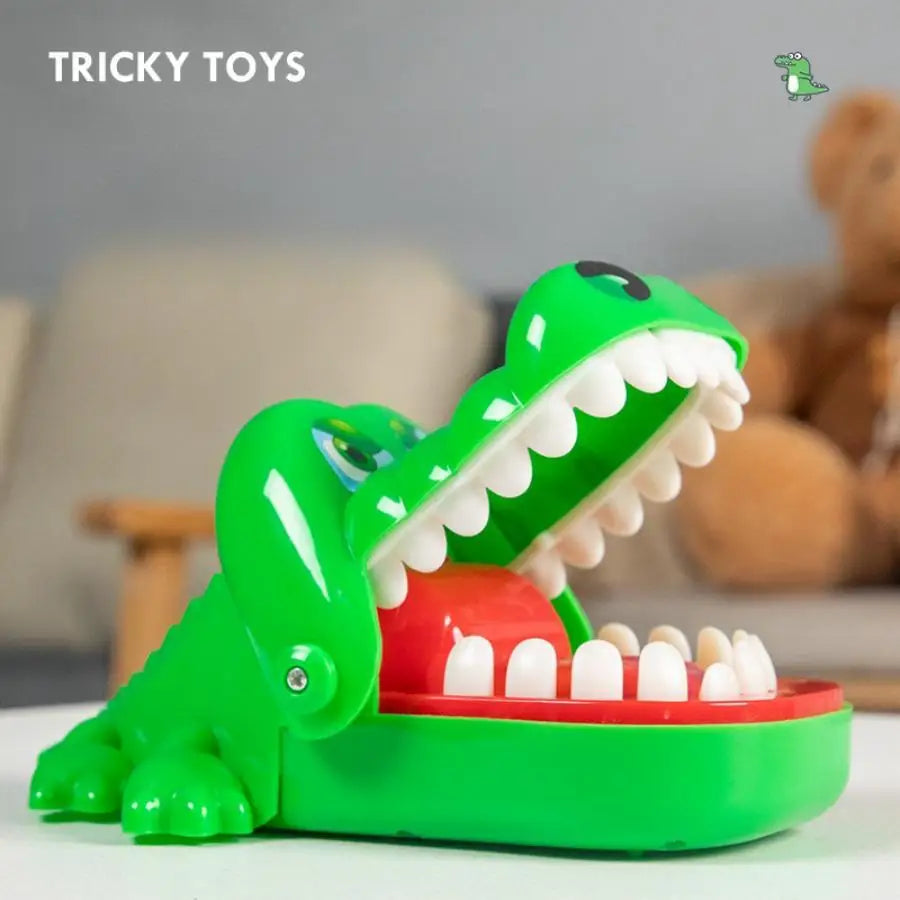 A bright green crocodile toy featuring large white teeth and an open mouth, designed for a biting finger game.