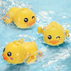 A set of yellow cartoon bath toys shaped like turtles, ducks, and whales floating in clear water.