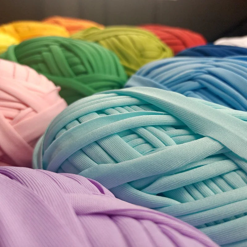 A close-up of various skeins of soft, pastel-colored polyester cloth yarn for crochet and knitting projects.
