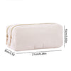 A cream-colored, ribbed pencil case with a zipper, shown in a side view.
